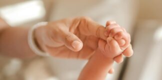 Dziecięca rączka zaciśnięta wokół palca dorosłej osoby